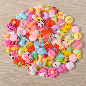 Macro shot of mixed resin DIY charms with cartoon animal, fruit, and heart shapes
