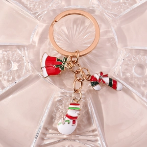 Détail d'un porte-clés de Noël avec breloques en émail de cloches, sucre d'orge et bonhomme de neige