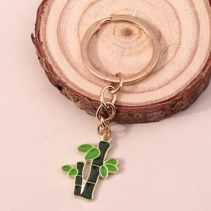 Détail d'un porte-clés doré avec un pendentif en émail vert représentant du bambou