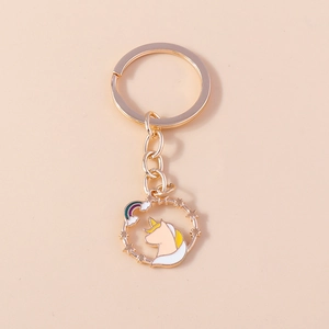 Detail of a gold unicorn keychain with rainbow and stars in a hollow circle pendant