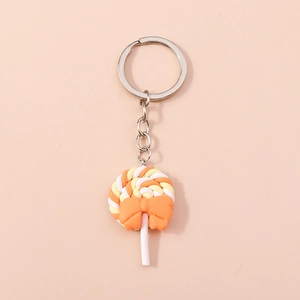 Close-up of orange swirl lollipop keychain with a bow and silver metal ring
