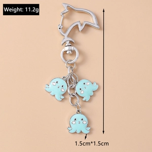 Detail of dolphin carabiner with three cute light blue octopus charms on metal chain