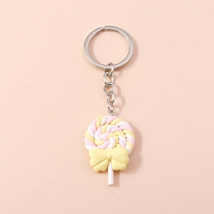 Detailed macro view of a pink spiral resin lollipop keychain with a small yellow bow