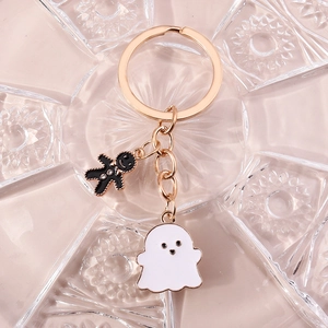 Détail d'un porte-clés doré avec charms de petit bonhomme de pain d'épices et fantôme