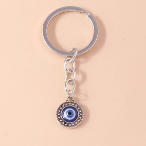Vue détaillée du porte-clés œil grec en argent avec perle bleue et pendentif en métal