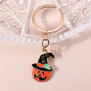Détail macro du porte-clés citrouille d'Halloween avec anneau doré sur plateau en verre