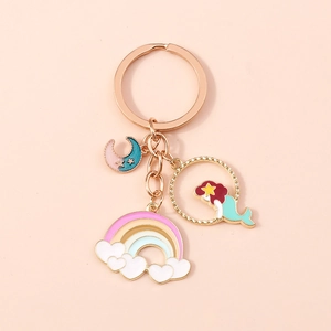 Dettaglio di un portachiavi a sirena in oro rosa con ciondoli a forma di arcobaleno e luna