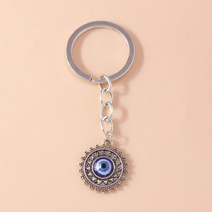 Vue détaillée du pendentif soleil argenté avec œil bleu sur porte-clés en métal
