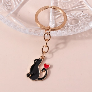 Vue détaillée du porte-clés chat noir émaillé avec cœur rouge et anneau doré brillant