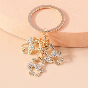 Luxurious gold bear keychain with hollow design and colorful rhinestone bowknot pendant