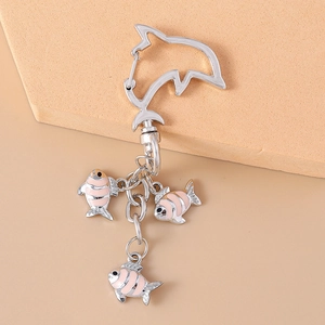 Detail of dolphin spring clasp and pink striped fish pendants on a silver metal keychain
