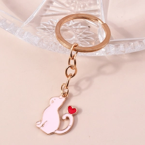 Gros plan du porte-clés chat en émail rose avec détail de cœur rouge et anneau doré