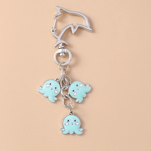 Close-up of ocean animal keychain with dolphin carabiner and blue enamel octopus charms