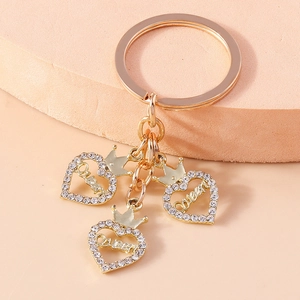 Porte-clés luxe coeur doré avec strass et pendentifs Queen sur fond rose