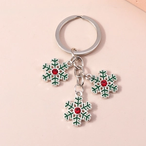 Gros plan du porte-clés flocon de neige en émail vert avec cristal rouge brillant