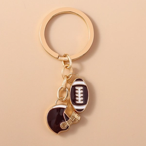 Gros plan détaillé des charms de porte-clés rugby et casque avec finition en émail