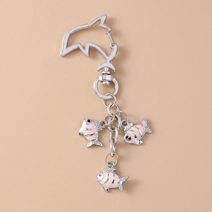 Detail of dolphin-shaped clasp and three pink striped fish charms for bags