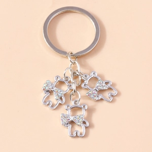 Detail of silver bear keychain with hollow design and sparkling rhinestone bows