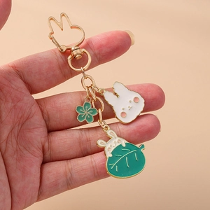 Porte-clés lapin mignon avec pendentifs carotte dorés et petite fleur verte