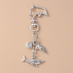 Detailed close-up of marine-themed metal keychain with shark, shell and conch pendants