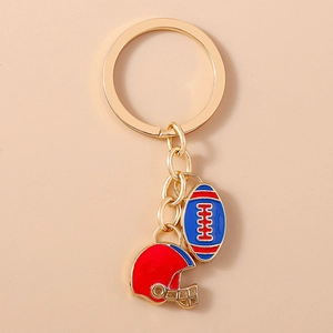 Détails rapprochés de pendentifs de rugby et casque doré sur un porte-clés en métal