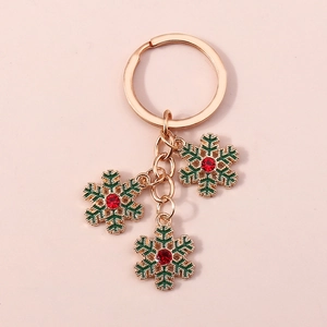 Détail d'un porte-clés de Noël avec pendentifs flocon de neige dorés et cristaux rouges
