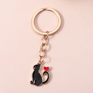 Vue détaillée du porte-clés chat noir avec breloque coeur rouge sur anneau doré