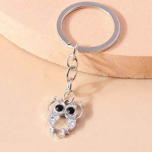 Sparkling rhinestone owl keychain with black gemstone eyes on a silver metal pendant