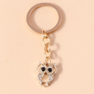Detailed view of the gold owl keychain featuring sparkling rhinestones and black gem eyes