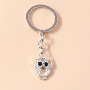 Close-up of silver owl keychain with black gemstone eyes and sparkling crystal details