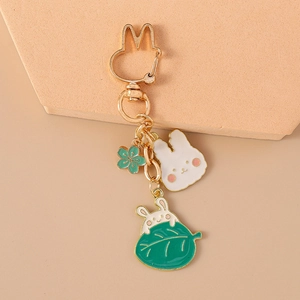 Vue détaillée de pendentifs lapin dorés et d'une breloque florale pour sac à main