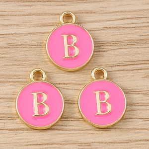 Close-up of pink enamel round letter B pendants with gold plating for DIY jewelry making