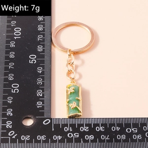 Close-up of green faux jade bamboo keychain with golden leaf metal accents and key ring