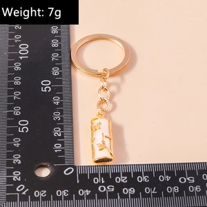 Detail of bamboo joint keychain pendant in gold and white weighing 7g on scale