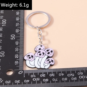 Macro detail of skeleton mushroom keychain featuring purple caps and silver metal ring