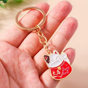 Classic golden Maneki Neko keychain with red and white enamel and Lucky charm text