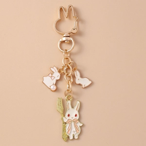Détail d'un porte-clés lapin en métal doré avec breloques en émail et fermoir forme lapin