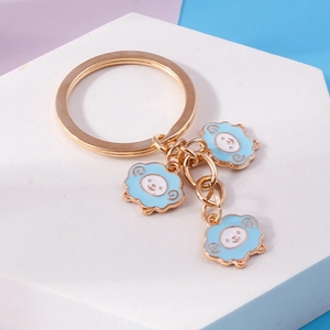 Golden keychain with three light blue enamel cloud pendants featuring cute smiling faces