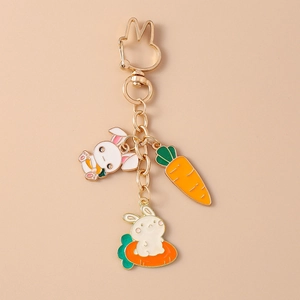 Détail d'un porte-clés lapin doré avec des pendentifs en émail carotte et lapin