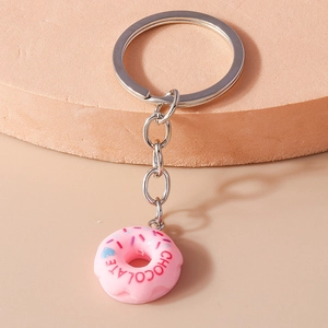 Macro detail of a pink donut keychain with colorful sprinkles and chocolate text