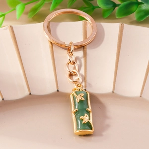 Elegant Chinese style jade bamboo keychain with gold leaf charm on decorative plate