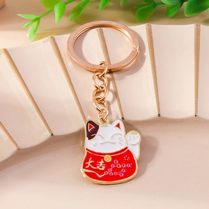 Minimalist fortune cat keychain with white enamel Lucky Cat and gold bell on cream background