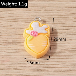 Detailed view of peach-shaped resin charm with pink flower and metal loop for DIY crafts
