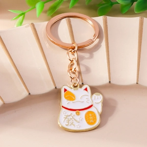 Detail of lucky cat keychain with rose gold plating and colorful enamel finish