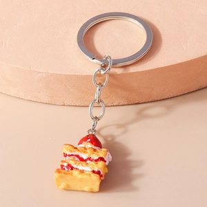 Close-up of a realistic strawberry Napoleon mille-feuille cake keychain with silver ring