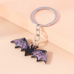 Detail of creative cartoon bat keychain with purple wings on light background