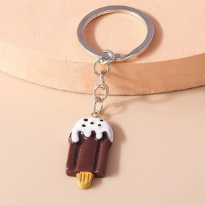 Close-up of a realistic chocolate popsicle keychain charm on a pink display stand