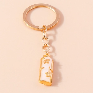 Detailed view of bamboo joint keychain with white jade-like finish and golden leaf carving