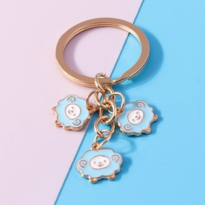Detailed view of three blue sheep enamel pendants on a polished gold-plated keychain