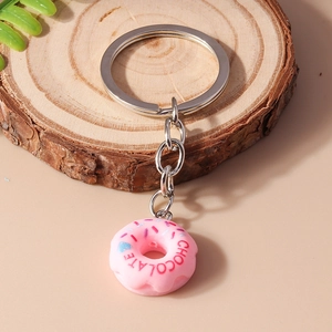 Close-up of a pink toy donut keychain with chocolate text and sugar needle decoration
